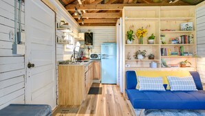 A compact kitchen with a refrigerator, microwave, and wooden cabinets.