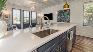 A modern kitchen with a large island, stainless steel appliances, and a pendant light. - Downtown Charleston! One block to King St. Free parking for two vehicles (Charleston)