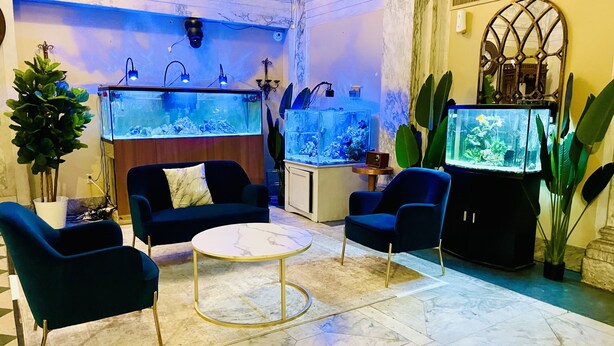 Un hall d’entrée doté d’un grand aquarium, de sièges confortables et d’un sol en marbre.