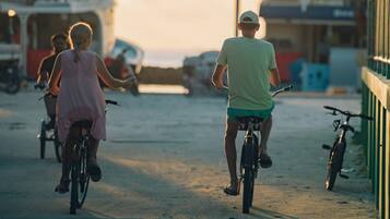 Escena de playa con gente andando en bicicleta.