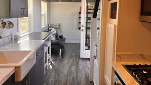 A compact kitchen with dark cabinets, a marble countertop, and a built-in oven. - Tiny Home, Lake View, RV & Boat Parking, Pistol Range. (davenport)