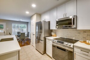 Enjoy cooking in this well-equipped kitchen with a refrigerator, microwave, and stove, and dine in the adjacent dining area.