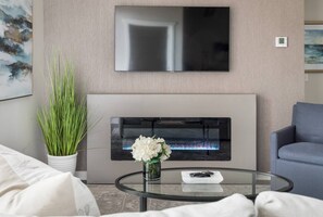 Een smart-tv, een open haard, boeken en een kantoor