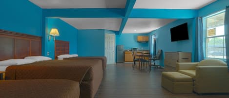 A hotel room with two beds, a desk, a chair, and a television.