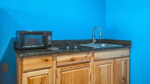 A kitchen with a microwave, stove, and sink. - Plaza Motel Corpus Christi By Oyo (Corpus Christi)