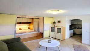 A compact living space with a bed, kitchenette, and a small dining area. - Green Terrace Apartment I (Dubrovnik)