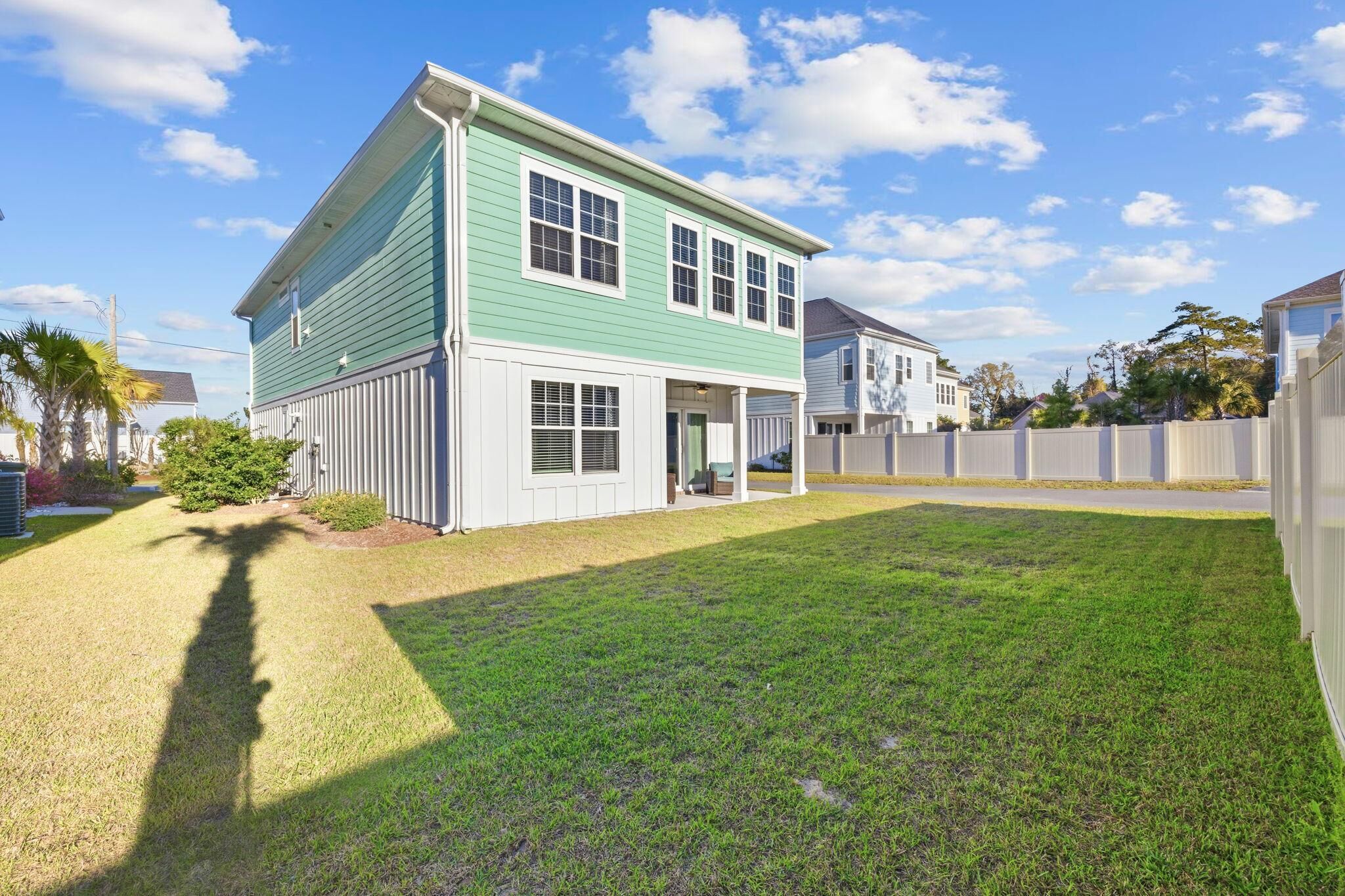 A two-story house with a front porch and a well-maintained lawn.