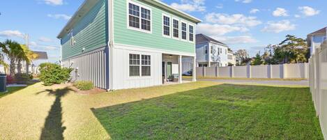 A two-story house with a front porch and a well-maintained lawn.