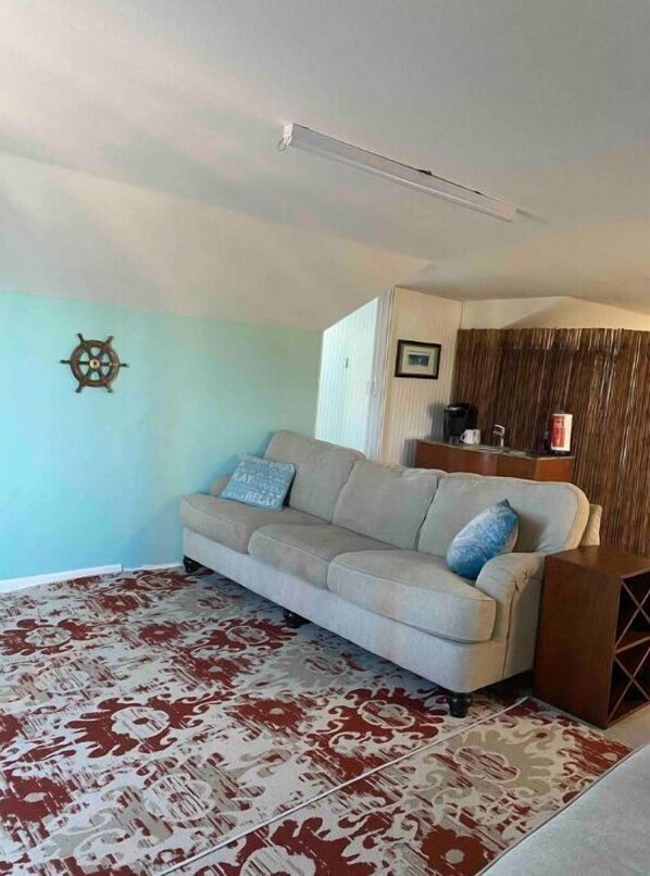 Relax in this inviting living space with a comfortable sofa, wooden cabinet, and framed artwork.