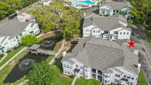 A residential area with houses, a swimming pool, and a pond.