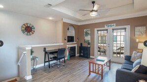 A spacious living room with a fireplace, a dining area, and a balcony with outdoor furniture.