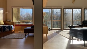 A modern bedroom with a large window, a bed, a desk, and a chair. - Scandinavian HideOut for Couples and Families, Firepit, Outdoor Games (Sevierville)