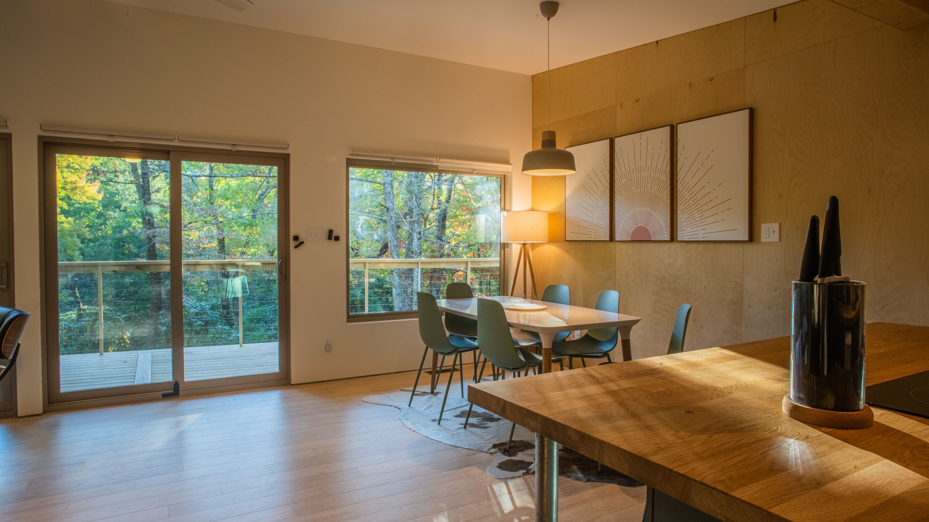 Un comedor moderno con una mesa de madera, sillas y una lámpara.