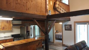Eine geräumige Küche mit Holzausstattung, einer großen Kochinsel und modernen Geräten.