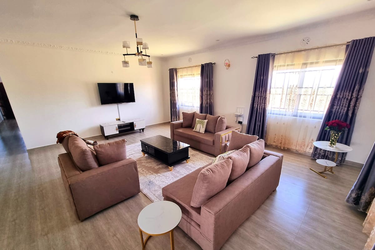 A modern living room with a sofa set, a coffee table, a TV, and a small side table.
