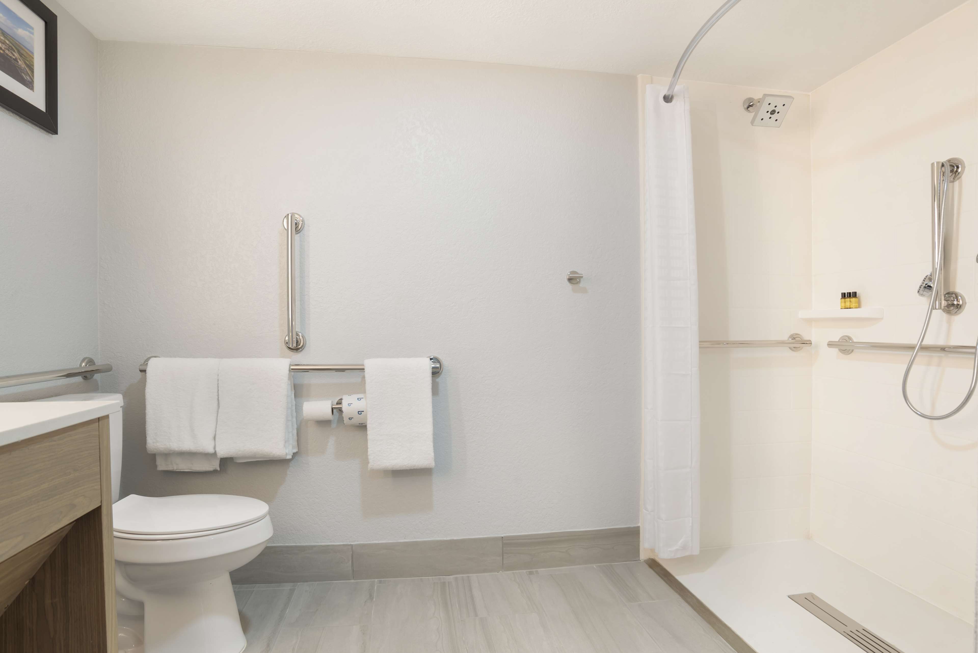 A modern bathroom with a toilet, a shower, and a sink.