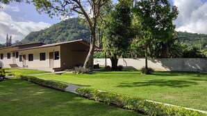 A well-maintained courtyard with a lawn, a small water feature, and a stone wall.