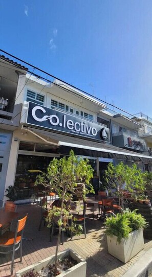 A building with a sign reading "Co.lectivo" and outdoor seating with potted plants. - El Rinconcito RV Experience 2.0! Private Pool (Rincón)