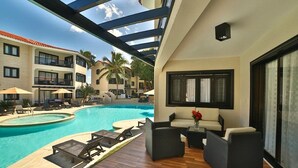 A hotel pool area with lounge chairs, a small table, and a sofa. - THE ROYAL SUITES - WALKING DISTANCE TO 8 BEACHES - ALL INCLUSIVE (Cofresi)