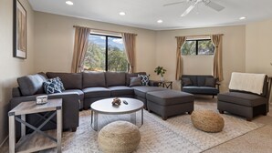 A modern living room with a sectional sofa, a round coffee table, and a small side table. - ✨ 3-King Beds / HotTub / EV Charger / Mountain View / Walk to River & Dining (Three Rivers)