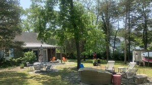 A backyard with a covered patio, outdoor furniture, and a large wicker sofa. - Catherine’s Place (Southampton)