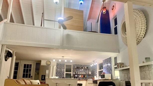 A spacious living area with a high ceiling, a dining table, a sofa, and a kitchen in the background. - Catherine’s Place (Southampton)