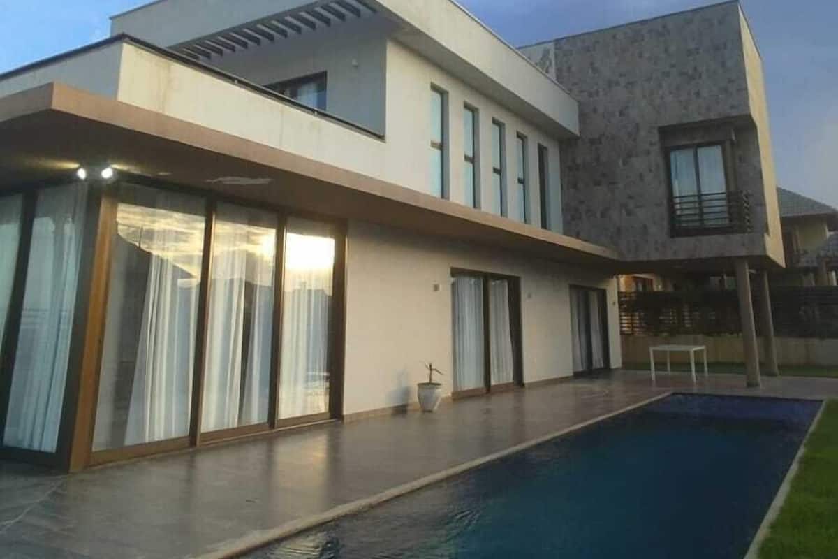 A modern two-story house with a swimming pool.