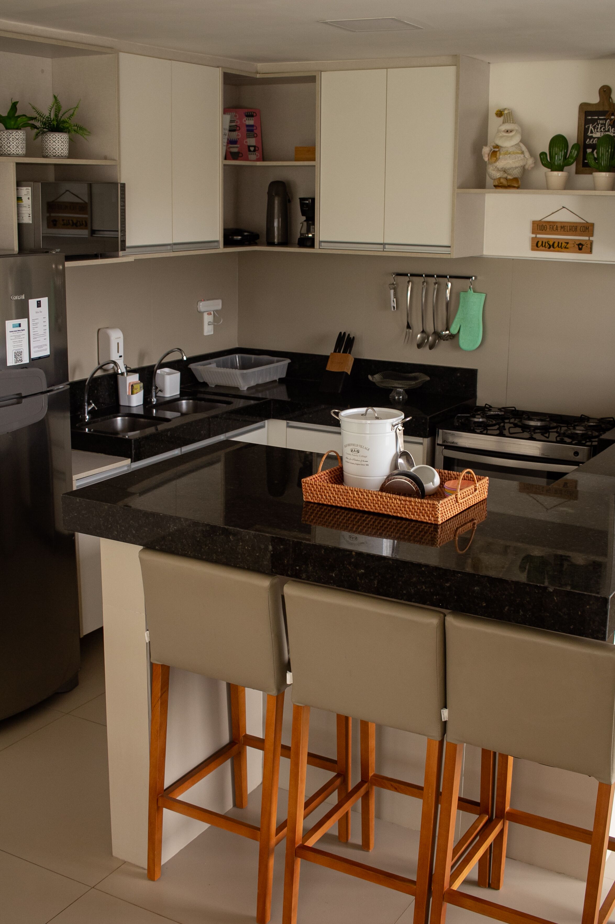 A modern kitchen with a central island, bar stools, and a variety of appliances including a refrigerator, stove, and sink.