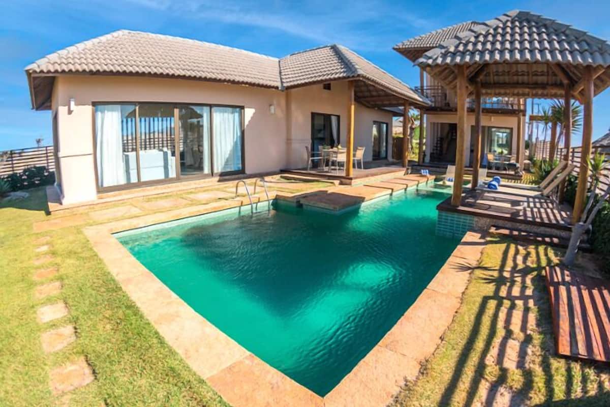 A house with a swimming pool, a covered patio, and a gazebo.