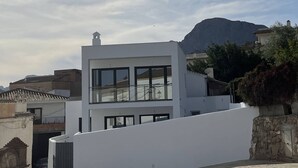Un edificio moderno de dos pisos con ventanas amplias y fachada blanca.