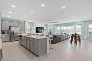 Enjoy meals in the spacious kitchen with a large island, sink, and stainless steel refrigerator.