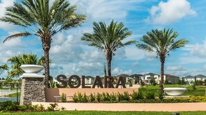 Welcome to Solara, a well-manicured community with residential buildings and lush palm trees.