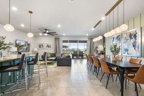 Relax in a stylish living area with a sofa, dining table, and kitchenette, offering a comfortable space to unwind and enjoy the view from the balcony.