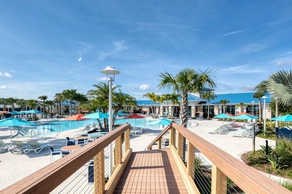 Relax by the pool surrounded by lush tropical plants and lounge chairs.