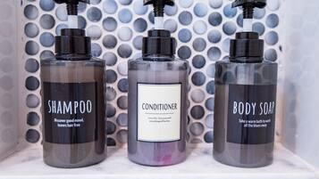 Tres botellas de productos de tocador en una estantería.