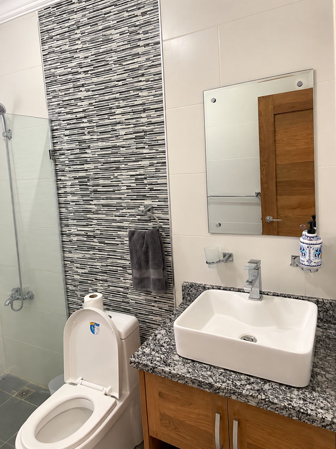 Un baño con inodoro, lavamanos y ducha.