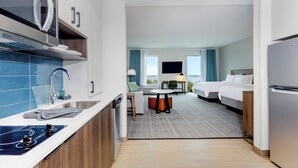 A modern hotel room with a kitchenette, a dining area, and a bed. - Staybridge Suites Winter Haven Auburndale by IHG (Winter Haven)
