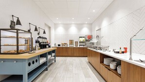 A modern kitchen with a wooden counter, coffee machines, and a Coca-Cola refrigerator. - Staybridge Suites Winter Haven Auburndale by IHG (Winter Haven)