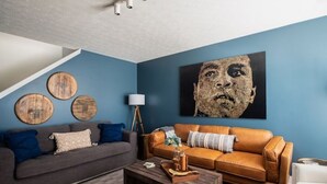 A living room with a blue wall, two sofas, a coffee table, and a lamp. - EVERYTHING LOUISVILLE GALLERY HOME 15% Discount (Louisville)