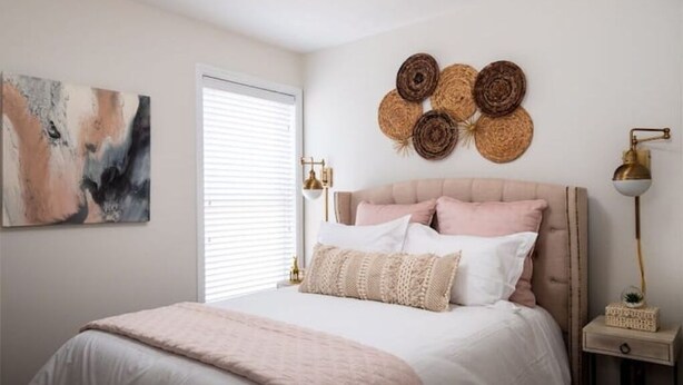 A bedroom with a bed, a wall-mounted artwork, a window with blinds, and a bedside table with a lamp. - EVERYTHING LOUISVILLE GALLERY HOME 15% Discount (Louisville)