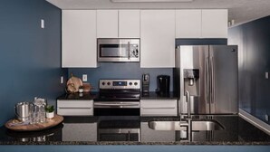 A modern kitchen with white cabinets, stainless steel appliances, and a granite countertop. - EVERYTHING LOUISVILLE GALLERY HOME 15% Discount (Louisville)