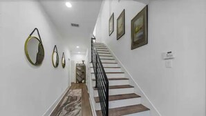 A staircase with wooden steps and a black railing, leading to an upper floor. - Stylish Cozy home near DT Houston and Medical Cntr (Houston)