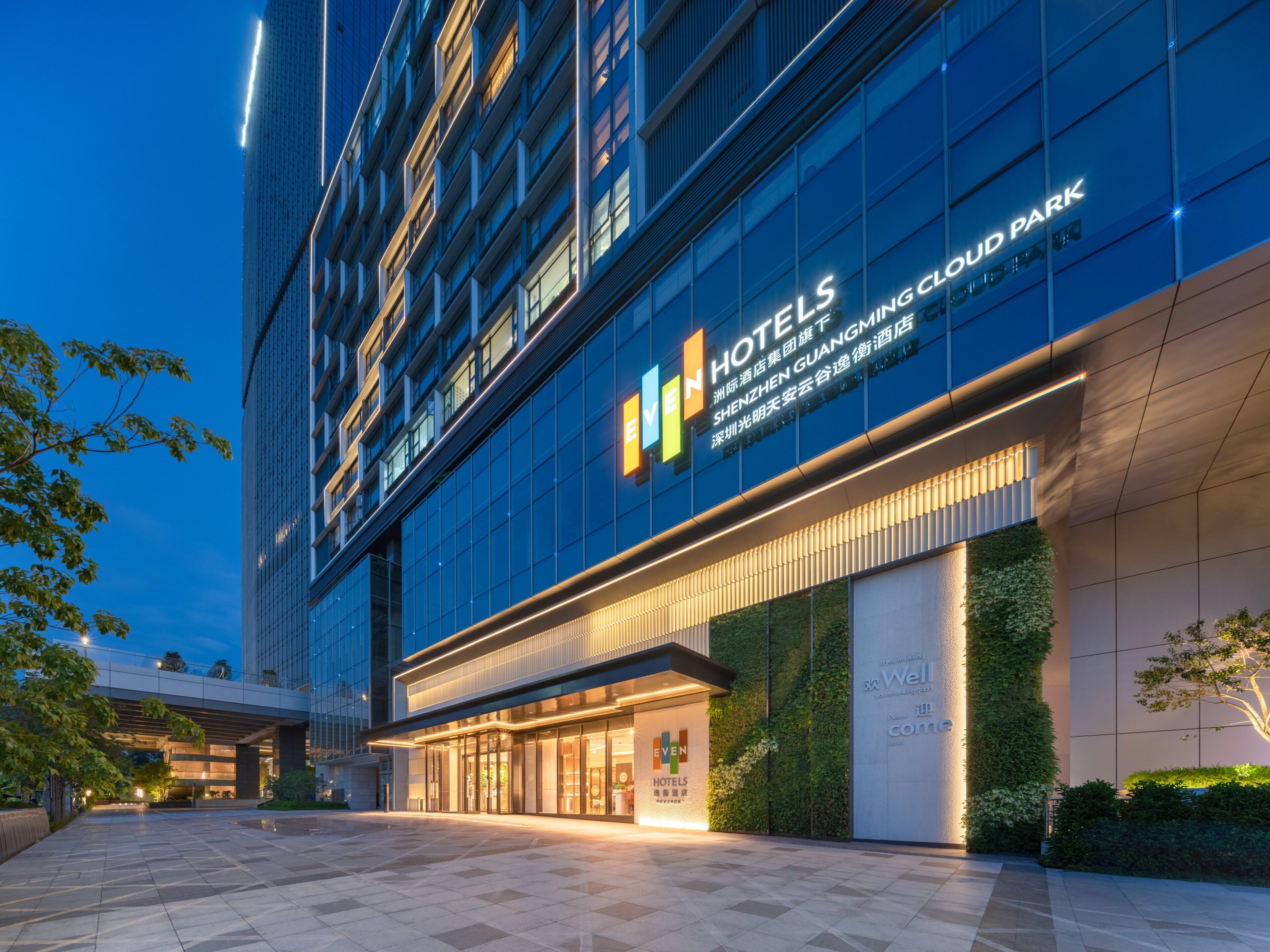 Een hotelgebouw met een moderne gevel, grote glasramen en een opvallend 'EVEN Hotels' bord.