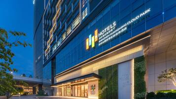 Een hotelgebouw met een moderne gevel, grote glasramen en een opvallend 'EVEN Hotels' bord.