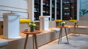 A modern reception area with a counter, seating, and a display of items on shelves. - EVEN Hotel Shenzhen Guangming Cloud Park by IHG (Shenzhen)