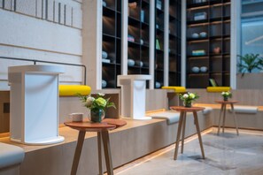 Una moderna zona de recepción con mostrador, asientos y una exhibición de objetos en estanterías.
