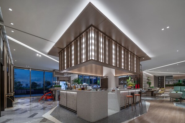 Una cocina moderna con una isla central, ventanas amplias y un comedor con asientos.
