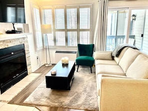 Relax in this stylish living room with a fireplace, flat-screen TV, and comfortable seating.