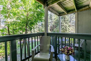 Relax in a serene outdoor space surrounded by lush greenery, with a comfortable chair and table for a peaceful retreat.