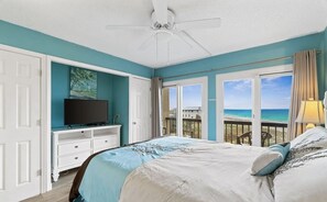 Relax in this serene bedroom with a large bed, ocean views, and a balcony.